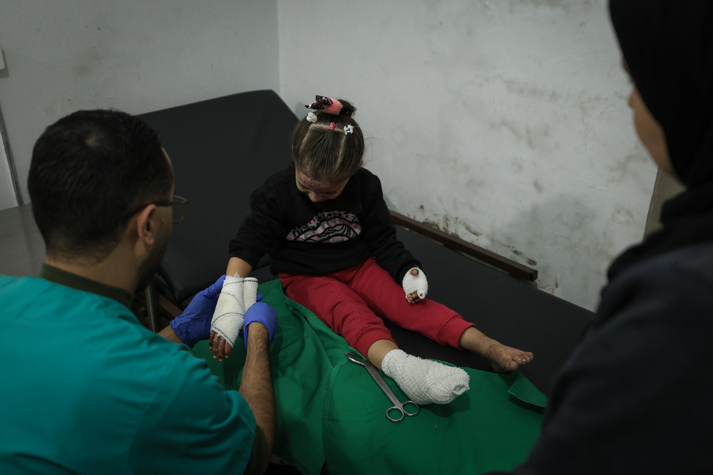 Pielęgniarz Lekarzy bez Granic zakłada opatrunek 4-letniej Sham w naszej przychodni w mieście Gaza. Sham doznała oparzeń, gdy jej dom został zbombardowany. Strefa Gazy, 2024