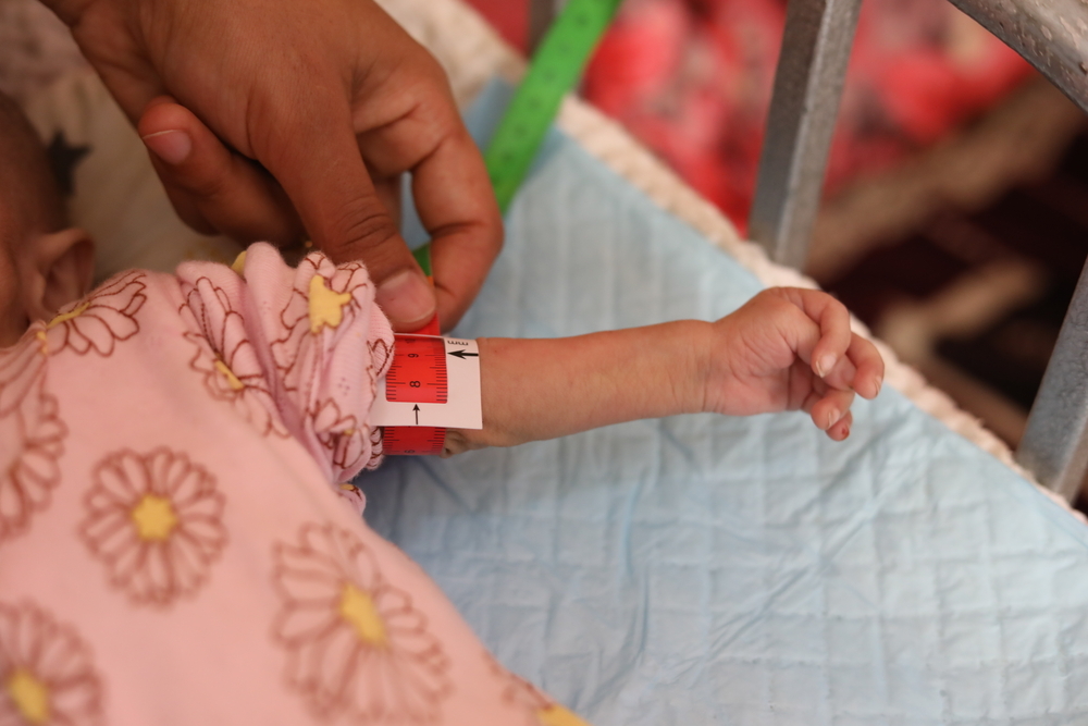 Hadisa Maman (32) karmi swoją córkę Zainab Osuman (2) na oddziale leczenia niedożywienia Szpitala Okręgowego Magaria. Niger, 2022