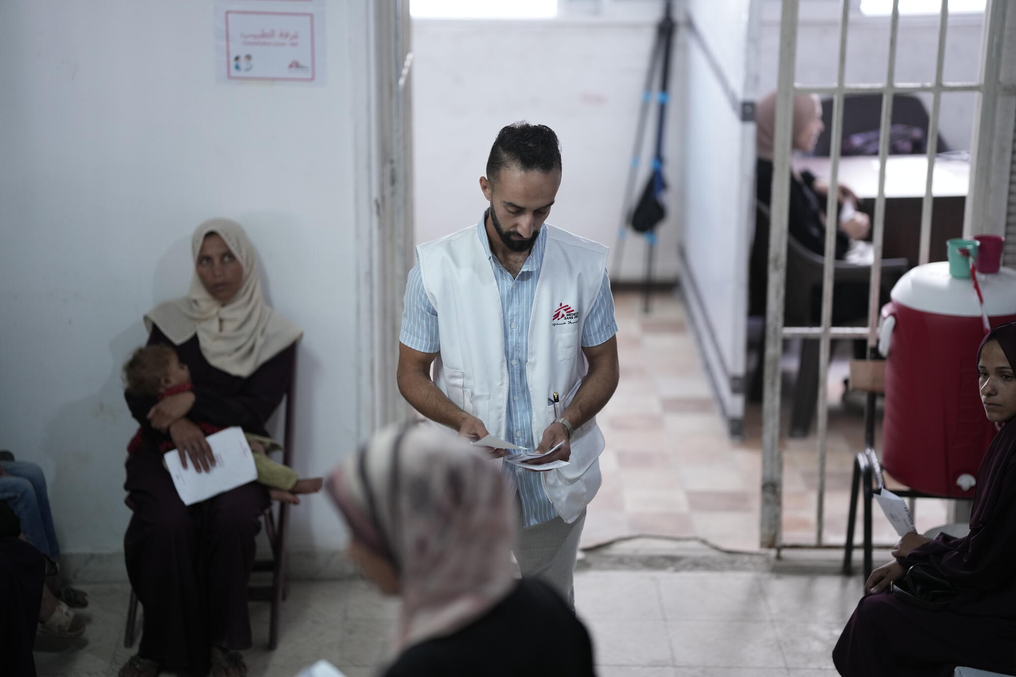 Pracownik Lekarzy bez Granic pomaga w organizacji przyjęć kolejnych pacjentów w klinice leczenia niedożywienia w Strefie Gazy. Gaza, czerwiec 2025