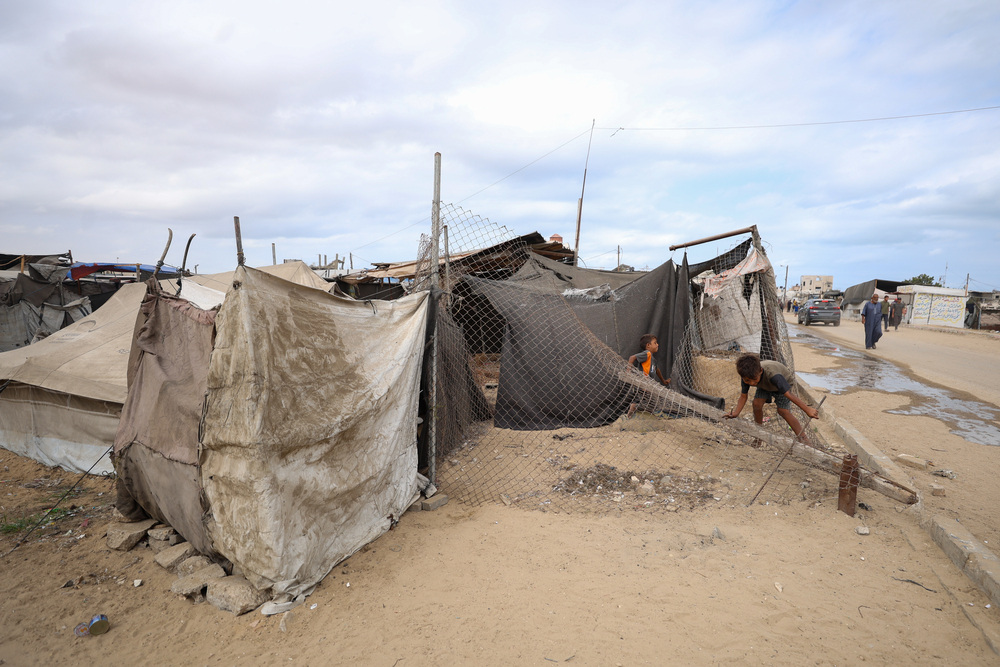 W Gazie brakuje bezpiecznych miejsc do zabawy. Dzieci w obozie dla osób przesiedlonych bawią się na przewróconym ogrodzeniu. Strefa Gazy, 2025