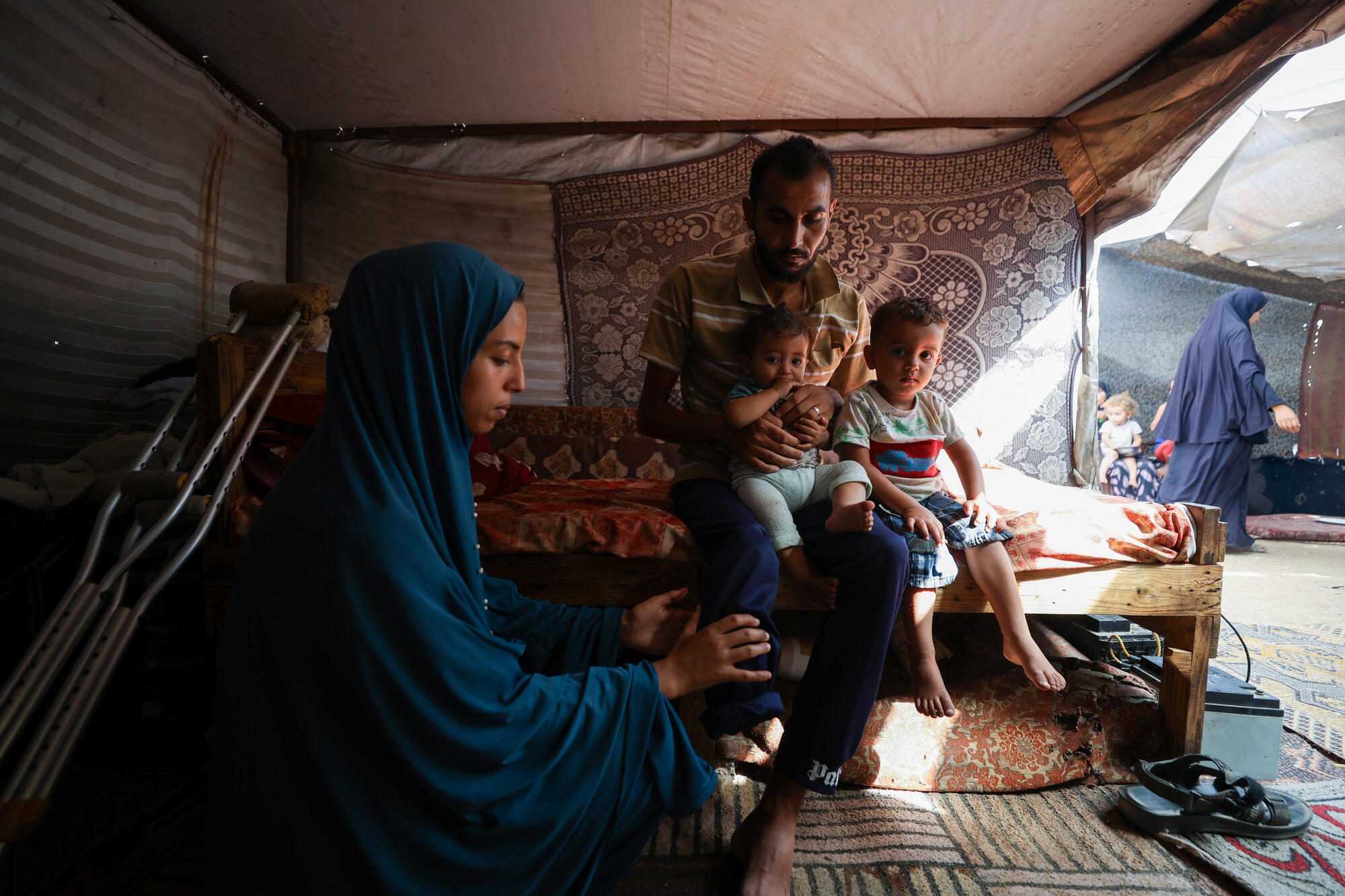Czteroosobowa rodzina została przesiedlona z Rafah do namiotu w Chan Junus. Mężczyzna stracił nogę, usiłując zdobyć pomoc humanitarną. Strefa Gazy, 2025